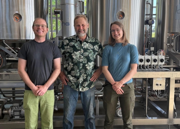 Cory Simon, left, Jeff Clawson and Jasmin Kennard in front of the vats in OSU's pilot brewery. 